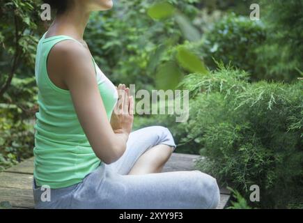 Young woman doing yoga asana dans la soirée à l'extérieur Banque D'Images