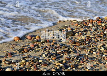 Cailloux colorés sur une plage ensoleillée et la mer surf Banque D'Images