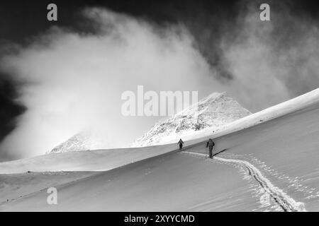 Randonneurs de ski en ascension dans la vallée de Stuor Reaiddavaggi, Kebnekaisefjaell, Norrbotten, Laponie, Suède, mars 2013, Europe Banque D'Images