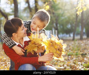 Mère et son fils marchant dans un parc d'automne Banque D'Images