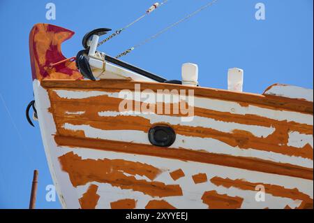 Gros plan de la proue d'un voilier avec peinture orange et blanche et ancre devant un ciel bleu, Patmos Marine, chantier naval, Diakofti, Patmos, Dodécanèse Banque D'Images