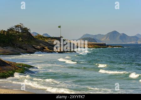 Avis de Devil's Beach et la forteresse de Copacabana avec drapeau brésilien et les collines de la ville de Niteroi dans l'arrière-plan Banque D'Images