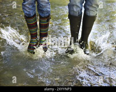 Heureux couple portant des bottes de pluie colorées. Bonheur et plaisir concept Banque D'Images