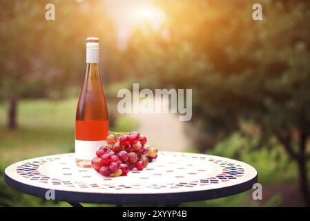 Une bouteille de vin rose en automne vignoble sur table de marbre. Temps de récolte, pique-nique ou de vin thème fest Banque D'Images