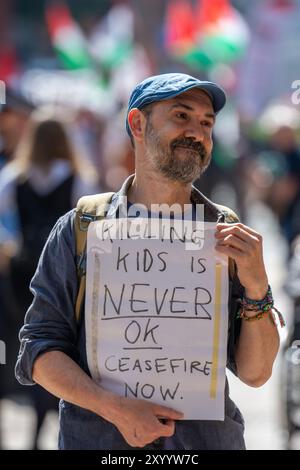 Manchester, Royaume-Uni. 31 août 2024. Homme avec une pancarte disant tuer des enfants n'est jamais OK et appelant au cessez-le-feu maintenant. Manifestants palestiniens à Manchester lors de leur 48ème week-end de protestation suite à l'attaque du Hamas le 7 octobre. Les manifestants ont défilé dans le centre de Manchester en commençant et en terminant à St Peter's Square. La marche s’est arrêtée au bâtiment d’assurance Axa, sur King Street, pour marquer leurs remerciements pour le désinvestissement de la société en Israël. Des bus et des tramways ont été retenus alors que la marche se déroulait sous escorte policière. Manchester Royaume-Uni. Picture garyroberts/Worldwidefeatures. Crédit : GaryRobertsphotogr Banque D'Images