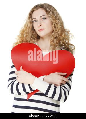 Fille blonde rêvante avec une grande carte de saint-valentin rouge Banque D'Images