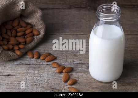 Le lait d'amande dans une bouteille sur la vieille table en bois Banque D'Images