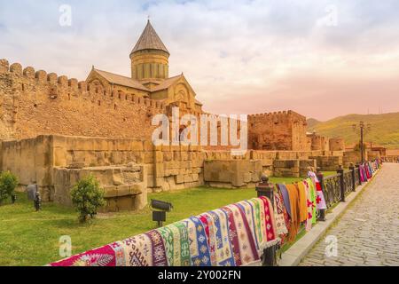 Mtskheta, Géorgie coucher de soleil vue sur la cathédrale orthodoxe géorgienne Svetitskhoveli, vente de tapis traditionnels Banque D'Images