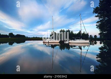 Deux charmants yachts sur la rivière le matin et la réflexion du ciel Banque D'Images