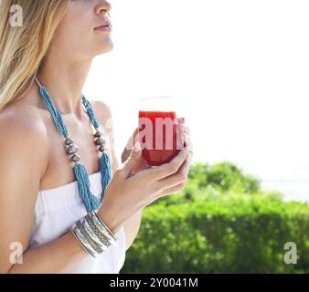 Femme tenant un verre de jus de fraises dans sa main part Banque D'Images
