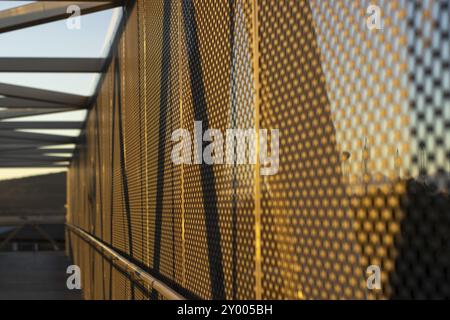 Panneaux composites en aluminium ou bardage avec des feuilles perforées sur la façade de bâtiment moderne au coucher du soleil, concept de fond d'architecture abstraite Banque D'Images