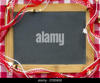 Blanc de tableau noir vintage encadré dans des décorations de Noël rouges. Concept de vacances d'hiver. Copiez l'espace pour votre texte Banque D'Images