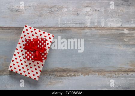 Coffrets cadeaux enveloppés dans du papier polkadots avec des rubans sur fond de bois, style rétro vintage Banque D'Images