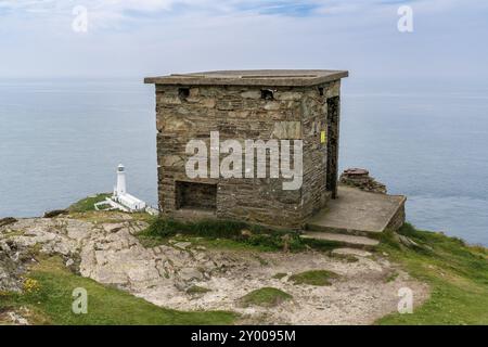 Près de Holyhead, Anglesey, Gwynedd, pays de Galles, Royaume-Uni, 08 juin 2018 : ancienne cabane de la Garde côtière avec le phare de South Stack en arrière-plan Banque D'Images