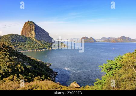 Vue sur le Pain de Sucre, colline de la baie de Guanabara, la mer, les collines et les montagnes de Rio de Janeiro avec la ville de Niteroi dans l'arrière-plan Banque D'Images