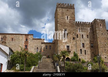 Steinburg mit Treppen und Vegetation vor einem bewoelkten Himmel, Wallfahrtskirche und Kloster, Real Monasterio de Nuestra Senora de Guadalupe, Guadal Banque D'Images