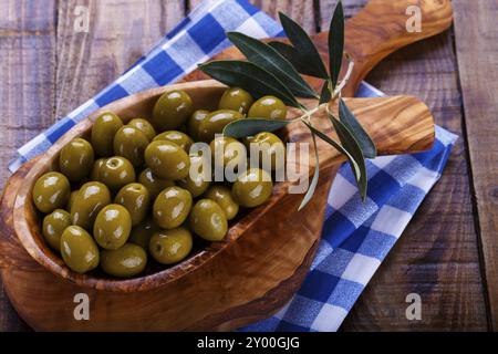 Olives vertes en bois d'bol sur fond en bois ancien. Vue de dessus avec l'espace pour le texte Banque D'Images