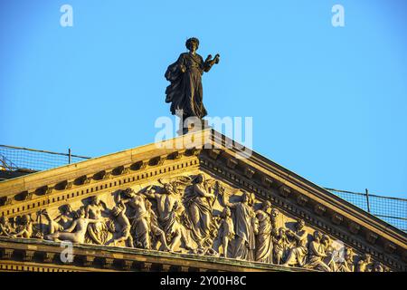 Statue noircie sur un fronton en grès avec relief Banque D'Images