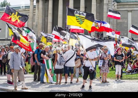 31 août 2024 : sous le nom de 'Grosser Treffen der 25 1 Bundesstaaten'', Reichsbuerger (ReichsbÃ¼rger, citoyens souverains, citoyens du Reich) s'est réuni sur la Koenigsplatz de Munich pour établir un réseau et nier la légitimité de la république allemande. Les Reichsbuerger ont été à l'origine banalisés et transformés en comédie dans les médias contre les avertissements de radicalisation par des experts jusqu'à ce qu'un raid à Georgesmund entraîne la mort d'un policier. L'affaire a également révélé Reichsbuerger dans la police et les structures étatiques mêmes dont ils nient la légitimité. À Munich, de nombreux Reichsbuerge connus Banque D'Images