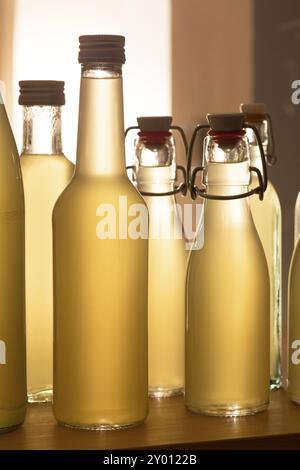 Bouteilles remplies de sirop de sureau contre la lumière Banque D'Images