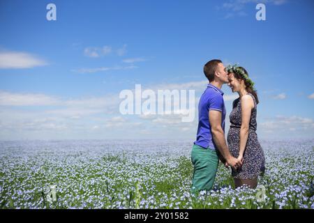 Portrait of a young happy pregnant couple dans champ de lin Banque D'Images