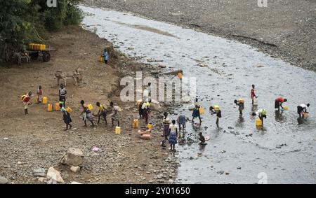 Des femmes et des filles vont chercher de l’eau dans des bidons en plastique dans une rivière près de la route d’Arba Minch à Konso, dans le sud de l’Éthiopie Banque D'Images