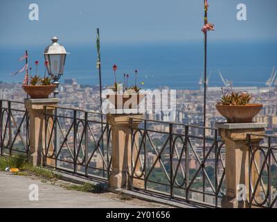 Vue sur une ville et la mer depuis un balcon avec des fleurs en jardinières, palerme, sicile, mer méditerranée, italie Banque D'Images