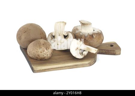 Champignons entiers Fresh Baby Bella ou Cremini sur planche à découper en bois isolée sur fond blanc Banque D'Images