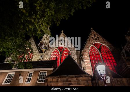 Fenêtres rouges illuminées de Oude Kerk la nuit - Amsterdam, pays-Bas Banque D'Images