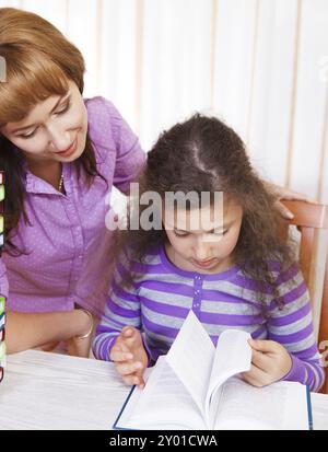 Petite fille avec et sa mère lisant le livre Banque D'Images