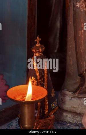 Image de la Vierge Marie apparaît sur un autel éclairé par une bougie pendant un office religieux dans l'intérieur du Brésil Banque D'Images