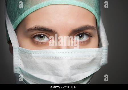 Closeup portrait of a doctor, avec un masque, dans un fond gris foncé Banque D'Images