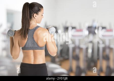 Close up de l'arrière d'un fit woman working out with dumbbells, isolé en gris Banque D'Images