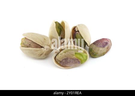 Pistaches en coquille et autres pelées exposant les noix vertes à l'intérieur isolé sur fond blanc Banque D'Images