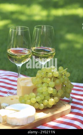 Diverses sortes de fromage, raisins et deux verres de vin blanc Banque D'Images