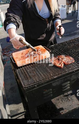 Une vue d'un cuisinier saisissant un steak de ribeye sur un bloc de sel rose de l'Himalaya, à l'aide d'une torche au butane, vu lors d'un festival alimentaire local. Banque D'Images