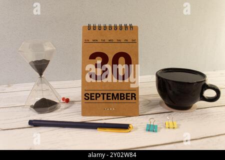 Septembre 30 sur un calendrier en bois à côté du réveil. Jour de septembre, espace vide pour le texte. Calendrier pour septembre sur fond clair Banque D'Images