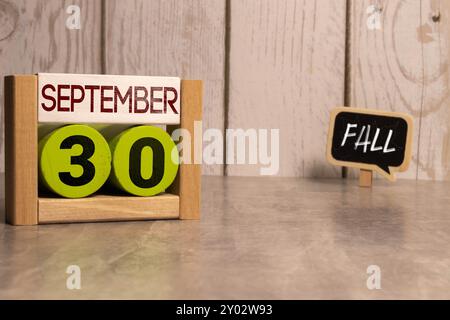 Septembre 30 sur un calendrier en bois à côté du réveil. Jour de septembre, espace vide pour le texte. Calendrier pour septembre sur fond clair Banque D'Images