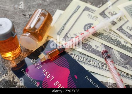 Ampoules avec des drogues, seringues, carte de crédit et argent sur fond grunge, gros plan Banque D'Images