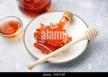 Bouteille de sirop d'érable savoureux sur fond gris Banque D'Images