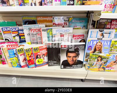 Paris, France - 23 août 2024 : plusieurs journaux et magazines français présentant la mort d'Alain Delon sur leurs couvertures exposées dans un kiosque de presse. Un hommage poignant à l'acteur légendaire Banque D'Images