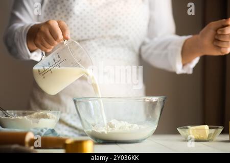 Femme préparant des rouleaux traditionnels à la cannelle dans la cuisine Banque D'Images