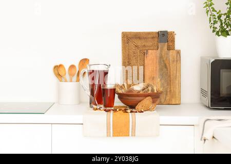 Pichet et verre de savoureux kvass avec du pain sur la table dans la cuisine Banque D'Images