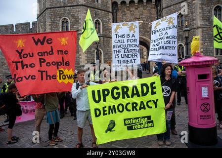 Windsor, Royaume-Uni. 31 août 2024. Les manifestants se tiennent debout avec des banderoles et des drapeaux à l'extérieur du château de Windsor, Windsor. Les membres de l'extinction Rebellion se sont rassemblés pour le week-end à Windsor, près du château. Week-end appelé «améliorer la démocratie» parce que selon la rébellion d'extinction le système politique est dépassé et il n'est pas capable de répondre à la crise climatique et écologique à laquelle l'humanité est confrontée. Crédit : SOPA images Limited/Alamy Live News Banque D'Images