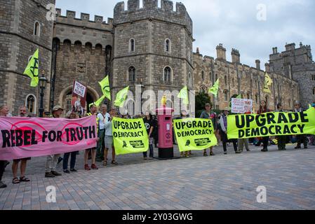 Windsor, Royaume-Uni. 31 août 2024. Les manifestants se tiennent devant le château de Windsor avec des banderoles et des drapeaux. Les membres de l'extinction Rebellion se sont rassemblés pour le week-end à Windsor, près du château. Week-end appelé «améliorer la démocratie» parce que selon la rébellion d'extinction le système politique est dépassé et il n'est pas capable de répondre à la crise climatique et écologique à laquelle l'humanité est confrontée. Crédit : SOPA images Limited/Alamy Live News Banque D'Images