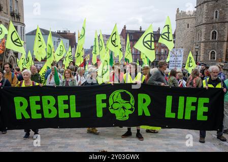 Windsor, Royaume-Uni. 31 août 2024. Les manifestants tiennent une bannière et des drapeaux à l'extérieur du château de Windsor, Windsor. Les membres de l'extinction Rebellion se sont rassemblés pour le week-end à Windsor, près du château. Week-end appelé «améliorer la démocratie» parce que selon la rébellion d'extinction le système politique est dépassé et il n'est pas capable de répondre à la crise climatique et écologique à laquelle l'humanité est confrontée. Crédit : SOPA images Limited/Alamy Live News Banque D'Images