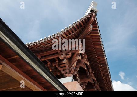 Une vue rapprochée d'un toit de temple japonais traditionnel, mettant en valeur l'artisanat en bois complexe et la conception architecturale. Banque D'Images