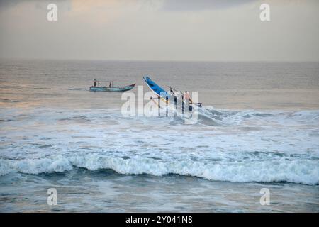 Purworejo, Java central, Indonésie. 30 août 2024. De petits bateaux transportant deux à trois pêcheurs ont bravé de hautes vagues par mauvais temps pour aller pêcher à la plage de Jatimalang sur AÄŸust, 30, 2024. Le mauvais temps et les vents violents n’ont pas découragé les pêcheurs de partir en mer. Ils ont utilisé leur instinct et leurs connaissances pour braver les vagues de huit mètres de haut pour se rendre au milieu de la mer, seuls quelques bateaux de pêche ont osé commencer à pêcher dès l’aube et revenir à midi parce qu’ils ne voulaient pas prendre trop de risques pendant la mauvaise saison météo. (Crédit image : © Dasril Roszandi/ZUMA Press Wire) EDITORIAL Banque D'Images