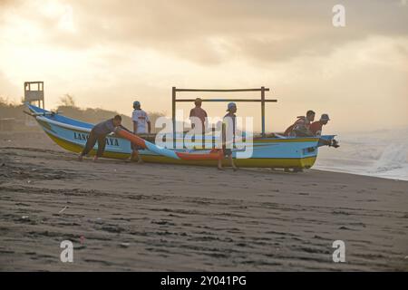 Purworejo, Java central, Indonésie. 30 août 2024. De petits bateaux transportant deux à trois pêcheurs ont bravé de hautes vagues par mauvais temps pour aller pêcher à la plage de Jatimalang sur AÄŸust, 30, 2024. Le mauvais temps et les vents violents n’ont pas découragé les pêcheurs de partir en mer. Ils ont utilisé leur instinct et leurs connaissances pour braver les vagues de huit mètres de haut pour se rendre au milieu de la mer, seuls quelques bateaux de pêche ont osé commencer à pêcher dès l’aube et revenir à midi parce qu’ils ne voulaient pas prendre trop de risques pendant la mauvaise saison météo. (Crédit image : © Dasril Roszandi/ZUMA Press Wire) EDITORIAL Banque D'Images