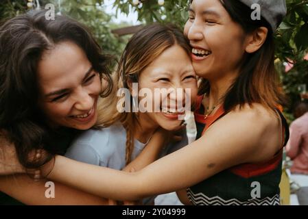 Amies féminines multiraciales joyeuses riant ensemble au dîner Banque D'Images